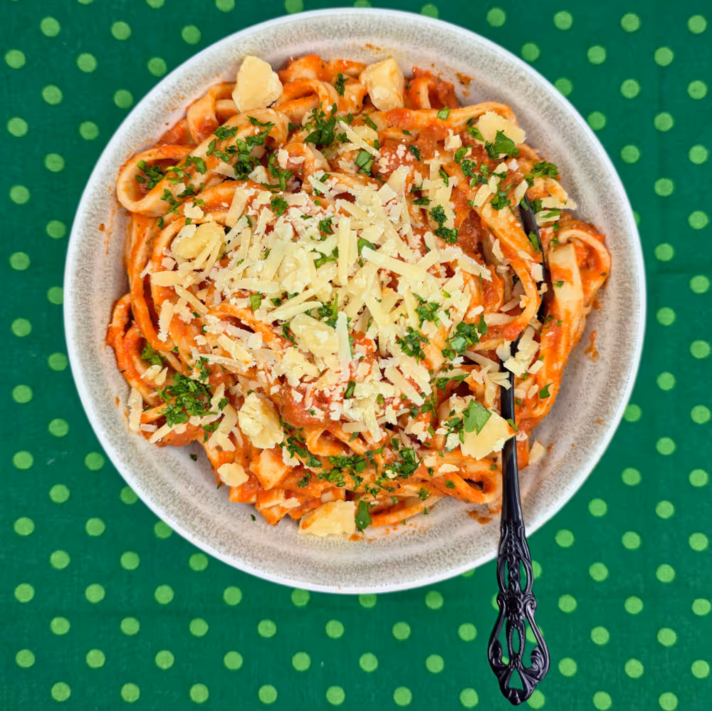  Ratatouille Pasta Sauce tossed through cooked, homemade pasta and topped with freshly grated parmesan cheese. Served in a bowl with a fork. 